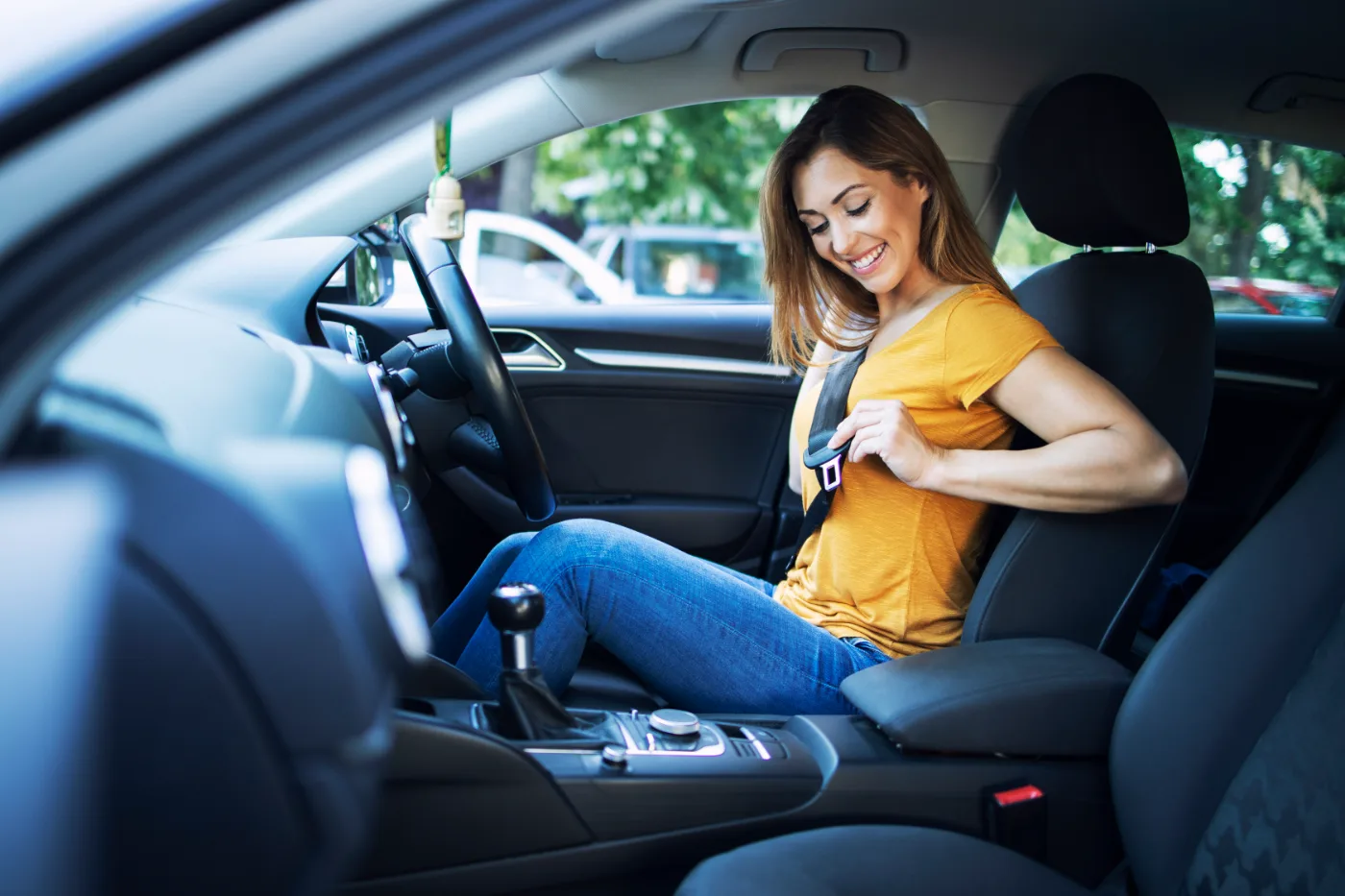 A learner driver fastening a seat belt before setting off