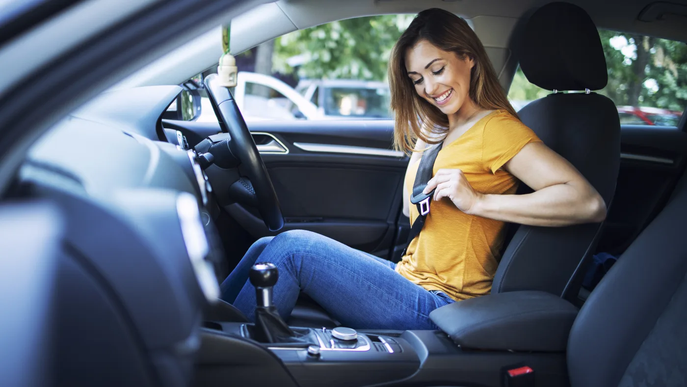A learner fastening her seat belt before starting a lesson