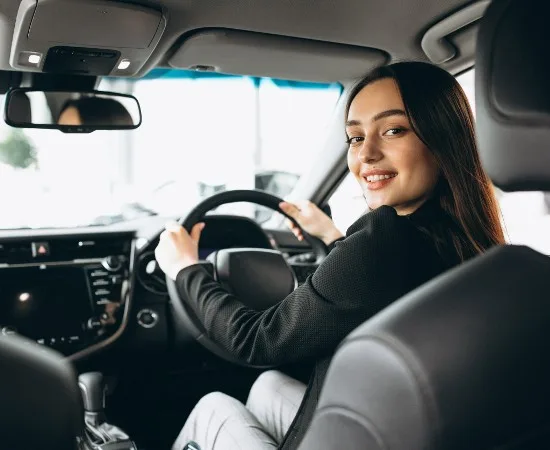 A young learner sitting in the driving seat before her first lesson